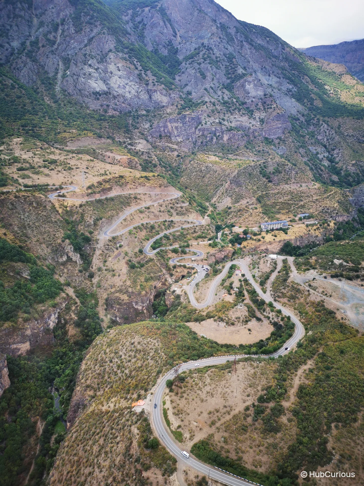 Hairpin road winding down into the wooded Vorotan gorge, seen from high up on the Wings of Tatev cable car