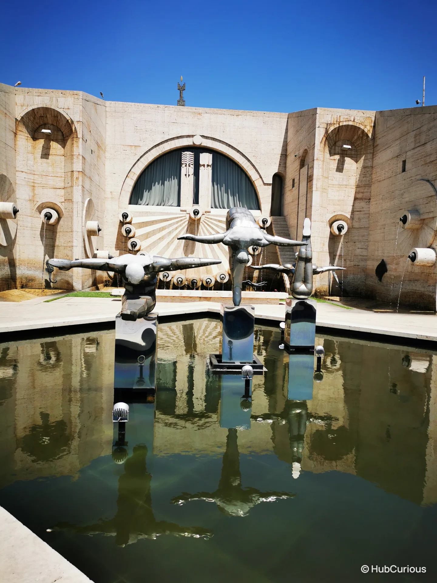 Three bronze swimmer figures diving over a reflecting pool on an upper terrace of the Cascade in Yerevan